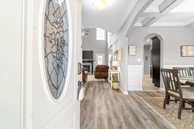 1148 Folly Beach Dr, Clarksville, TN 37042 - entryway with arched walkways, crown molding, a glass covered fireplace, light wood-style flooring, and ceiling fan