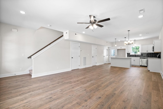 198 Cave St Unit C, Clarksville, TN 37042 - unfurnished living room featuring ceiling fan, wood finished floors, a chandelier, recessed lighting, and stairs