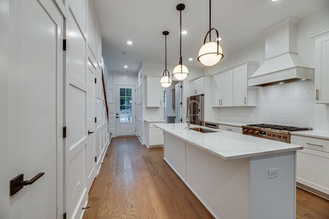 117 Shadow Springs Dr Unit 117, Brentwood, TN 37027 - kitchen with premium range hood, decorative backsplash, wood finished floors, recessed lighting, and a center island with sink