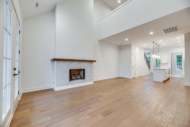 117 Shadow Springs Dr Unit 117, Brentwood, TN 37027 - unfurnished living room featuring light wood-type flooring, a premium fireplace, and recessed lighting