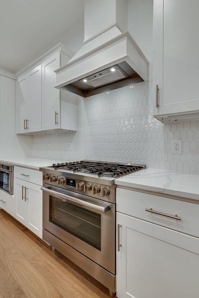 117 Shadow Springs Dr Unit 117, Brentwood, TN 37027 - kitchen featuring gas stove, premium range hood, white cabinets, and tasteful backsplash