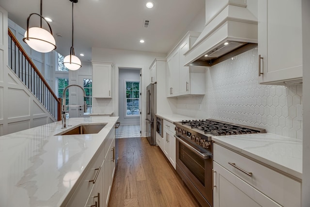 117 Shadow Springs Dr Unit 117, Brentwood, TN 37027 - kitchen with high end appliances, custom exhaust hood, wood finished floors, white cabinets, and decorative backsplash