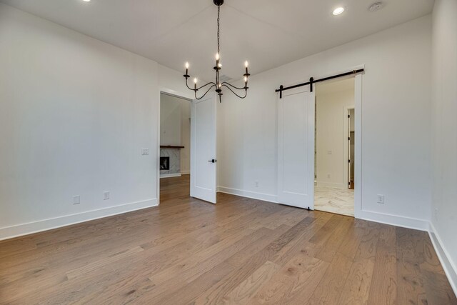 117 Shadow Springs Dr Unit 117, Brentwood, TN 37027 - unfurnished dining area featuring a barn door, a chandelier, wood finished floors, and recessed lighting