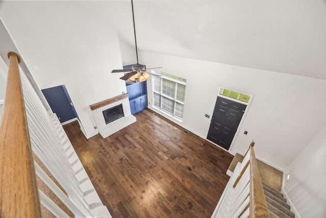 2135 Loudenslager Dr, Thompsons Station, TN 37179 - unfurnished living room with a fireplace, high vaulted ceiling, stairs, a ceiling fan, and dark wood finished floors