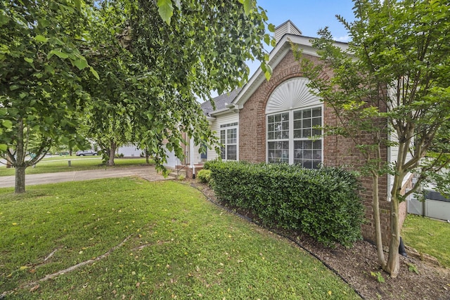 2135 Loudenslager Dr, Thompsons Station, TN 37179 - view of side of property featuring brick siding, a lawn, a chimney, and roof with shingles