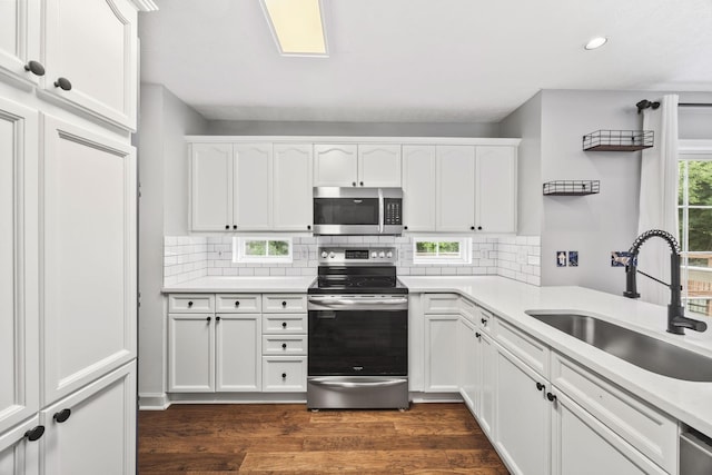 2135 Loudenslager Dr, Thompsons Station, TN 37179 - kitchen with stainless steel appliances, white cabinets, dark wood-style flooring, decorative backsplash, and recessed lighting