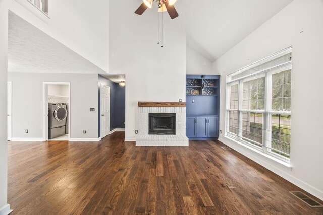 2135 Loudenslager Dr, Thompsons Station, TN 37179 - unfurnished living room with a brick fireplace, high vaulted ceiling, dark wood-type flooring, a ceiling fan, and washer and clothes dryer