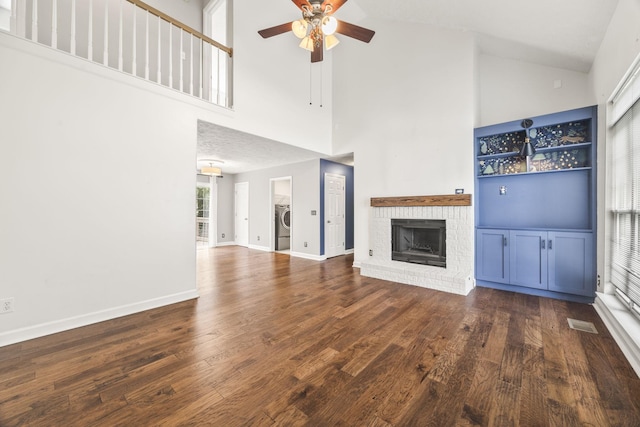 2135 Loudenslager Dr, Thompsons Station, TN 37179 - unfurnished living room with high vaulted ceiling, a ceiling fan, a fireplace, wood finished floors, and washer / clothes dryer