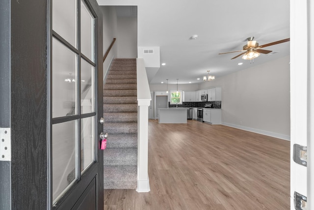109 Adkins St Unit A, Clarksville, TN 37042 - unfurnished living room with light wood-style flooring, stairway, ceiling fan, recessed lighting, and a chandelier
