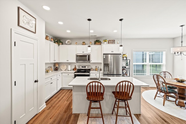 1425 Village Loop, Cookeville, TN 38501 - kitchen with appliances with stainless steel finishes, light wood-style floors, recessed lighting, a kitchen island with sink, and white cabinets
