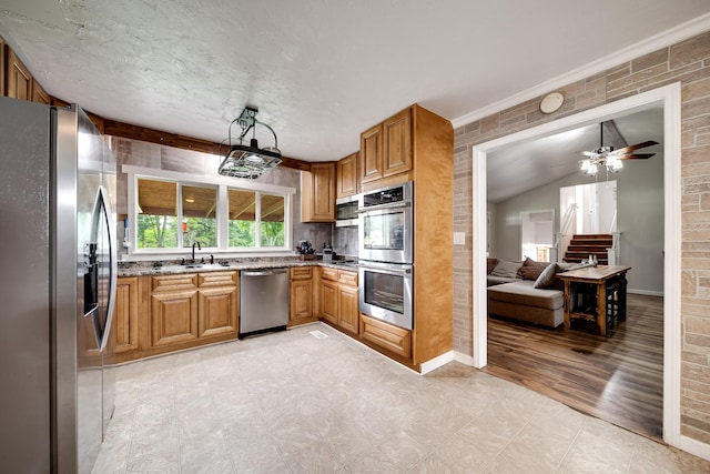 3037 Tunnel Rd, Westmoreland, TN 37186 - kitchen featuring appliances with stainless steel finishes, light stone counters, brown cabinets, light flooring, and a ceiling fan