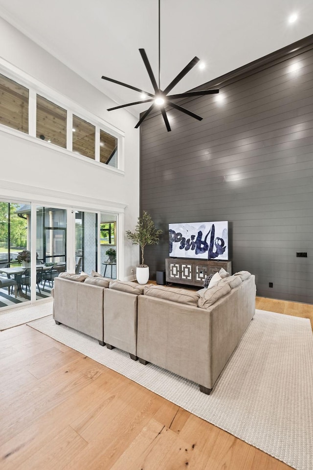 1485 Harrison Rd, Murfreesboro, TN 37128 - living room featuring a high ceiling, a ceiling fan, light wood-type flooring, and wooden walls