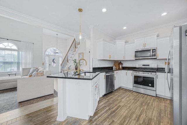 134 Chisum Ct, Clarksville, TN 37043 - kitchen featuring stainless steel appliances, open floor plan, dark countertops, a peninsula, and white cabinets