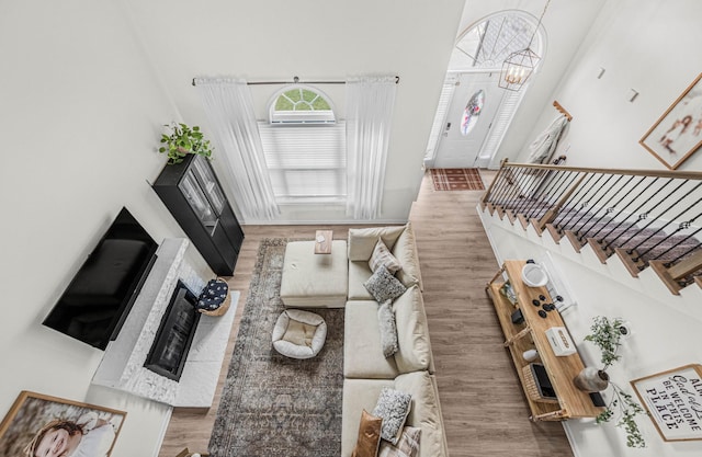 134 Chisum Ct, Clarksville, TN 37043 - living area featuring a high ceiling, wood finished floors, stairway, a chandelier, and a brick fireplace