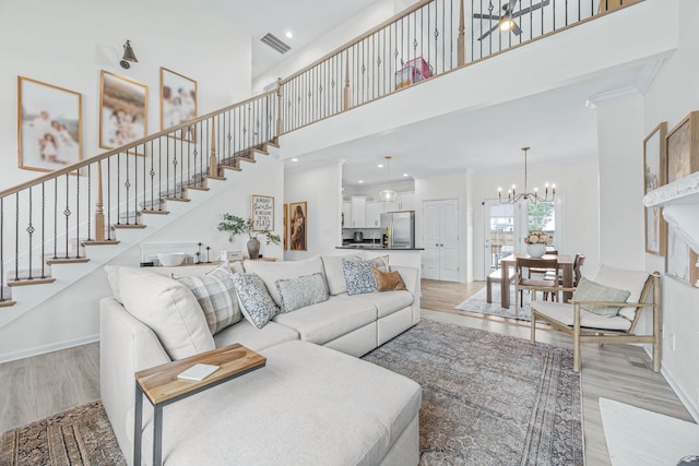 134 Chisum Ct, Clarksville, TN 37043 - living area featuring a chandelier, light wood-style floors, stairway, a towering ceiling, and crown molding