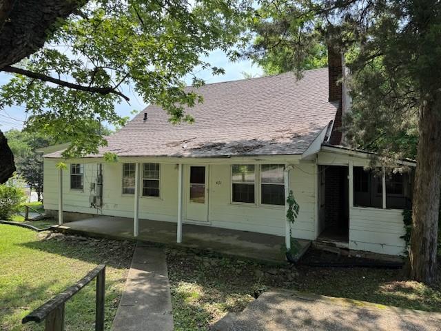 421 Hickman St, Columbia, TN 38401 - view of front of house featuring a chimney, a patio area, a front yard, roof with shingles, and a sunroom