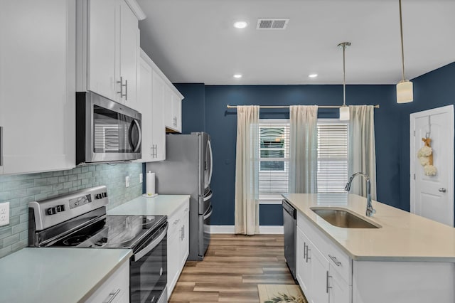 652 Taylor Bend Rd, Columbia, TN 38401 - kitchen featuring stainless steel appliances, light countertops, decorative backsplash, white cabinets, and light wood-style floors