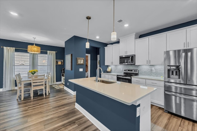 652 Taylor Bend Rd, Columbia, TN 38401 - kitchen featuring appliances with stainless steel finishes, decorative backsplash, light countertops, wood finished floors, and white cabinetry