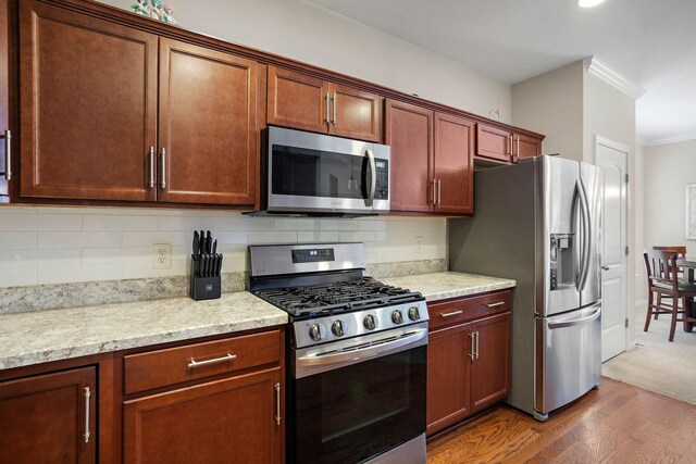 341 Lola Ln, Cottontown, TN 37048 - kitchen featuring stainless steel appliances, crown molding, dark wood-style floors, and backsplash