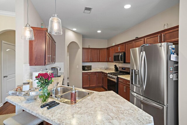 341 Lola Ln, Cottontown, TN 37048 - kitchen featuring appliances with stainless steel finishes, arched walkways, a peninsula, wood finished floors, and recessed lighting