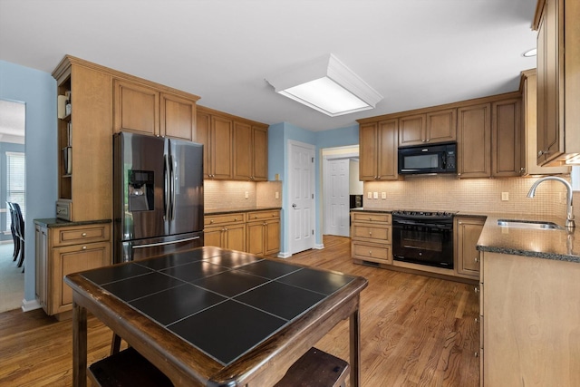 3604 Gentry Station Dr, Signal Mountain, TN 37377 - kitchen with black appliances, wood finished floors, tasteful backsplash, and brown cabinets