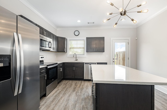 121 Bellvue Dr, Lebanon, TN 37090 - kitchen with appliances with stainless steel finishes, ornamental molding, light wood-style flooring, a kitchen island, and a chandelier