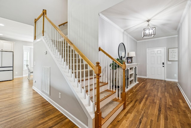 1005 Rudder Dr, Spring Hill, TN 37174 - foyer with wood finished floors, a chandelier, crown molding, and stairs