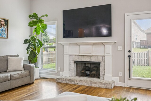 1005 Rudder Dr, Spring Hill, TN 37174 - living area featuring wood finished floors, a brick fireplace, and plenty of natural light