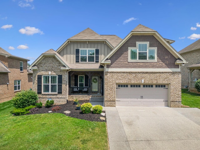 1005 Rudder Dr, Spring Hill, TN 37174 - view of front of house with board and batten siding, covered porch, a front yard, driveway, and an attached garage