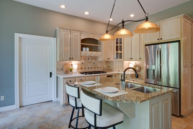101 Oak Dr, Waverly, TN 37185 - kitchen featuring stainless steel fridge, backsplash, black gas cooktop, a center island with sink, and a breakfast bar