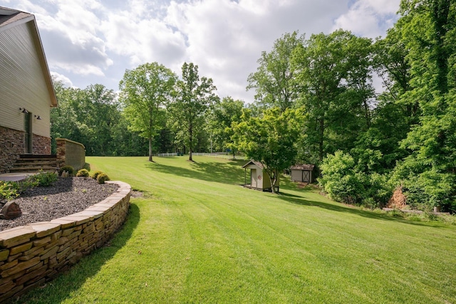 101 Oak Dr, Waverly, TN 37185 - view of grassy yard featuring a storage unit and view of wooded area
