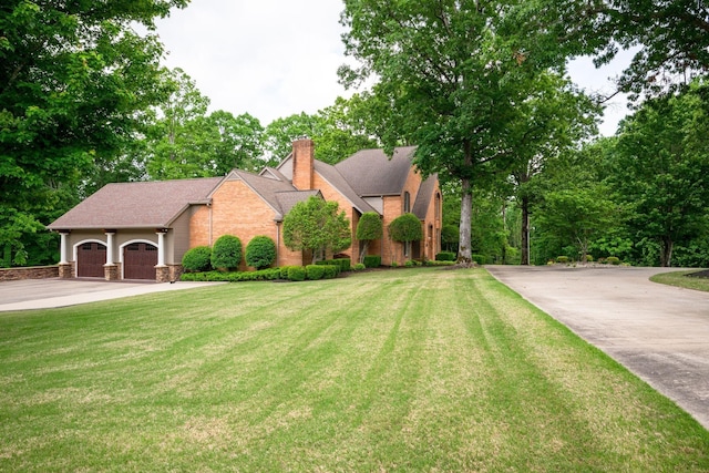 101 Oak Dr, Waverly, TN 37185 - view of front of property featuring concrete driveway, a chimney, a front lawn, and roof with shingles