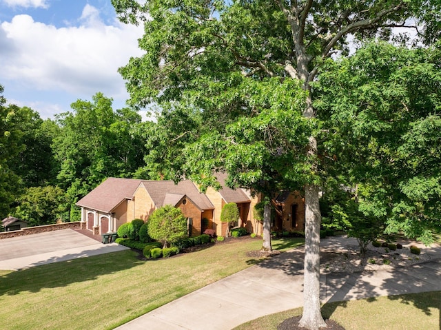 101 Oak Dr, Waverly, TN 37185 - obstructed view of property featuring driveway, a front lawn, a garage, and brick siding