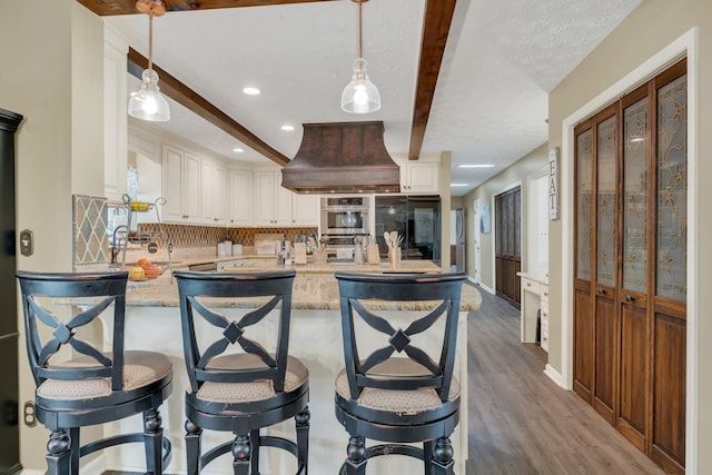 2600 Clanton Rd, Lawrenceburg, TN 38464 - kitchen featuring custom range hood, tasteful backsplash, oven, a peninsula, and light stone countertops