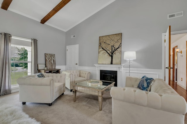 2600 Clanton Rd, Lawrenceburg, TN 38464 - living area featuring beamed ceiling, high vaulted ceiling, a glass covered fireplace, wainscoting, and a decorative wall