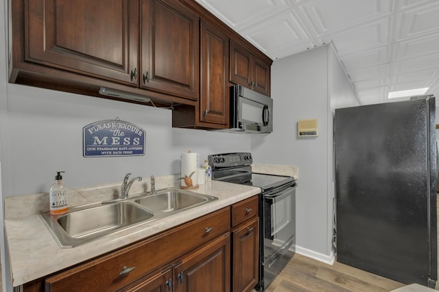 2600 Clanton Rd, Lawrenceburg, TN 38464 - kitchen with black appliances, light wood-style flooring, light countertops, and an ornate ceiling