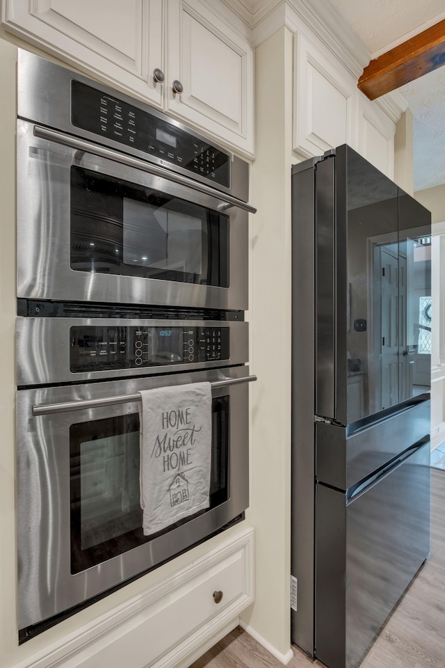 2600 Clanton Rd, Lawrenceburg, TN 38464 - kitchen featuring appliances with stainless steel finishes, light wood-style flooring, and white cabinets