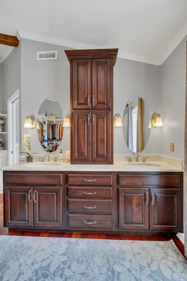2600 Clanton Rd, Lawrenceburg, TN 38464 - full bathroom featuring crown molding, double vanity, wood finished floors, and a textured ceiling