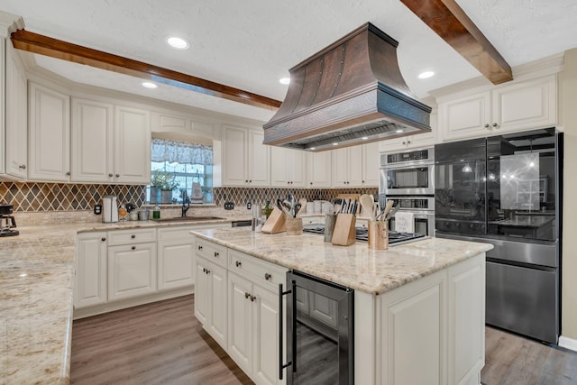 2600 Clanton Rd, Lawrenceburg, TN 38464 - kitchen featuring stainless steel appliances, beverage cooler, island range hood, beamed ceiling, and tasteful backsplash