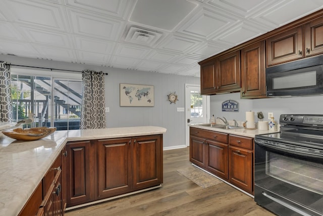 2600 Clanton Rd, Lawrenceburg, TN 38464 - kitchen featuring black appliances, wood finished floors, an ornate ceiling, and light stone counters