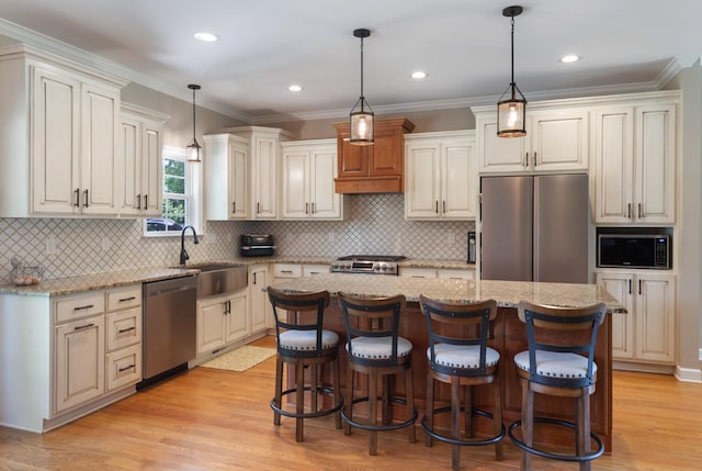 3215 Church St, Burns, TN 37029 - kitchen with stainless steel appliances, a center island, light wood-type flooring, light stone countertops, and ornamental molding