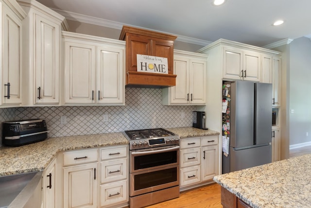 3215 Church St, Burns, TN 37029 - kitchen with stainless steel appliances, crown molding, tasteful backsplash, light stone countertops, and light wood-style flooring