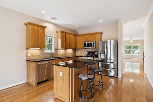2025 Morrison Ave, Spring Hill, TN 37174 - kitchen with appliances with stainless steel finishes, light wood-style floors, a kitchen bar, a kitchen island, and healthy amount of natural light