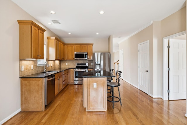 2025 Morrison Ave, Spring Hill, TN 37174 - kitchen with appliances with stainless steel finishes, a breakfast bar, light wood finished floors, backsplash, and recessed lighting