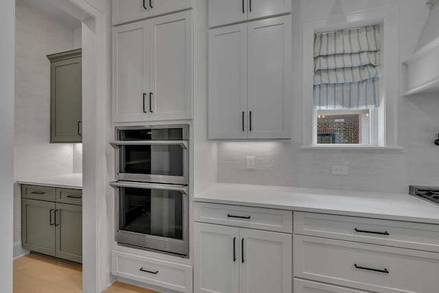 6060 Pasquo Rd, Nashville, TN 37221 - kitchen featuring stainless steel double oven, light countertops, backsplash, and wallpapered walls