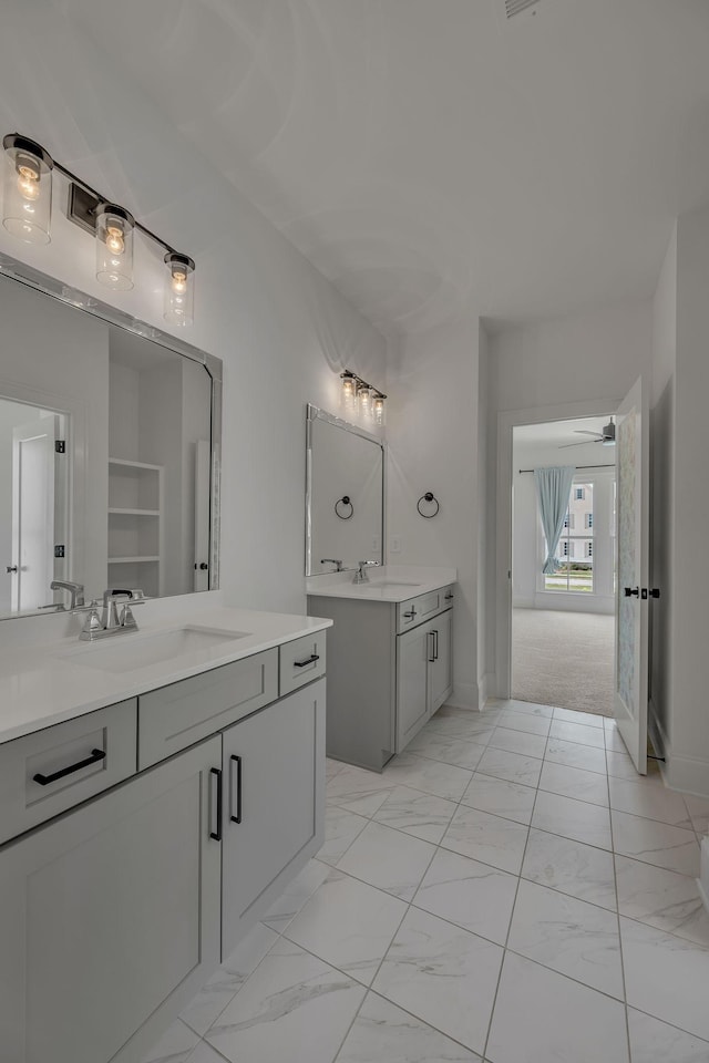 6060 Pasquo Rd, Nashville, TN 37221 - bathroom with two vanities, marble look tile flooring, and ceiling fan