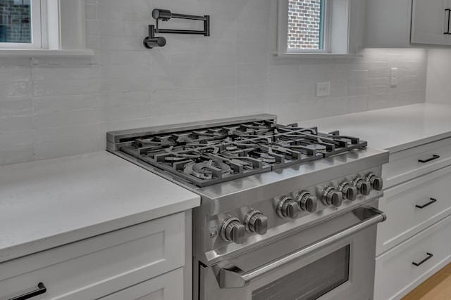 6060 Pasquo Rd, Nashville, TN 37221 - kitchen view of high end stove, pot filler, backsplash, and white cabinetry