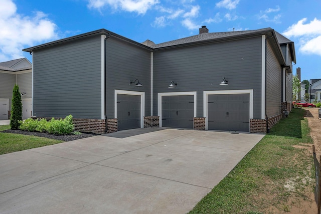 6060 Pasquo Rd, Nashville, TN 37221 - view of side of home featuring driveway, brick siding, a chimney, and a garage