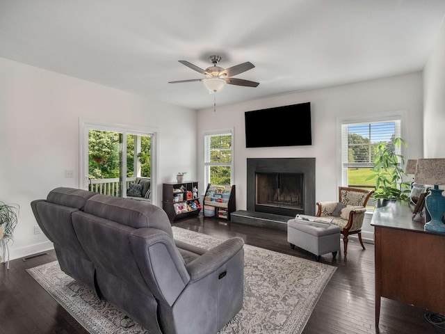 7811 Lampley Rd, Primm Springs, TN 38476 - living room featuring healthy amount of natural light, a fireplace with raised hearth, ceiling fan, and dark wood finished floors