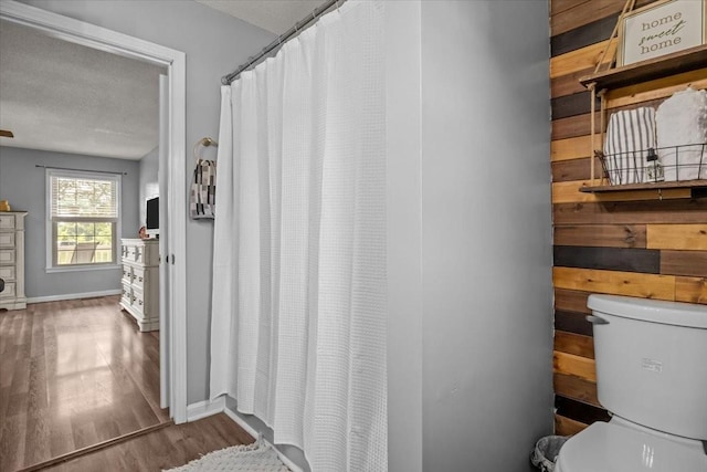 5455 Bales Rd, Cunningham, TN 37052 - full bath with wood finished floors, curtained shower, and a textured ceiling